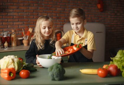bambini che versano verdura verde in una ciotola