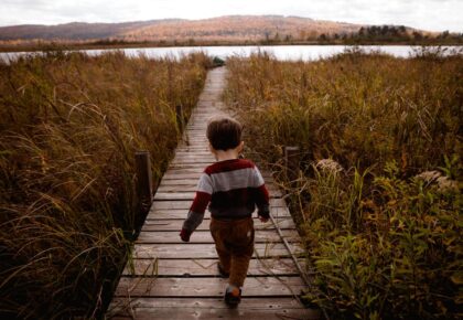 bambino che cammina su passerella in autunno